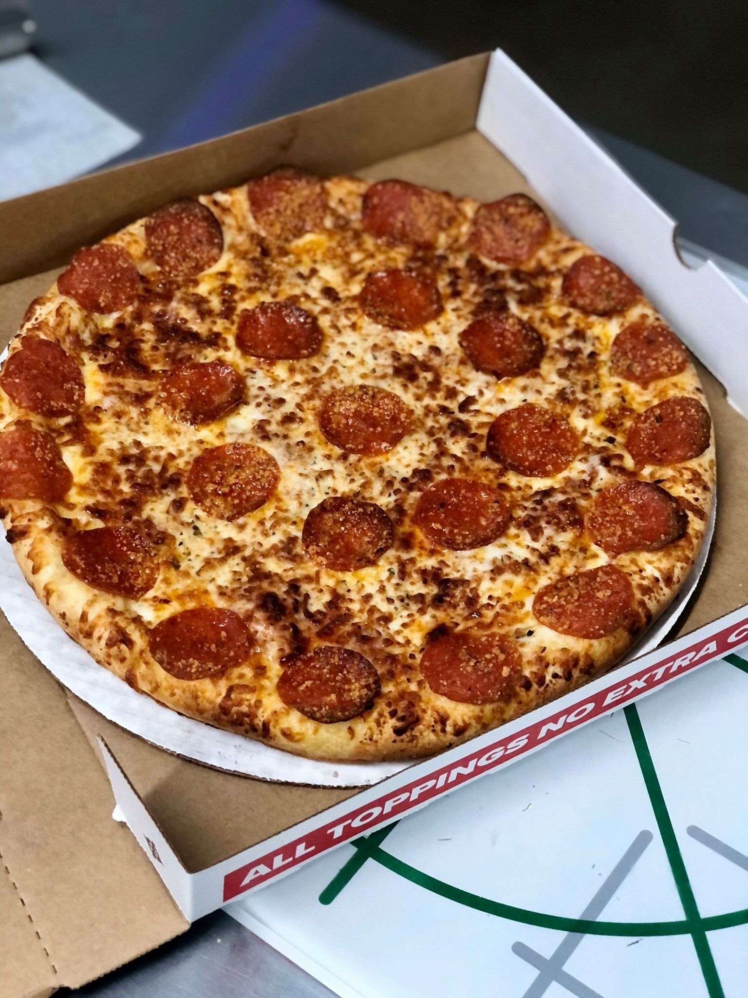 A lush green field with trees in the background on a cloudy day.