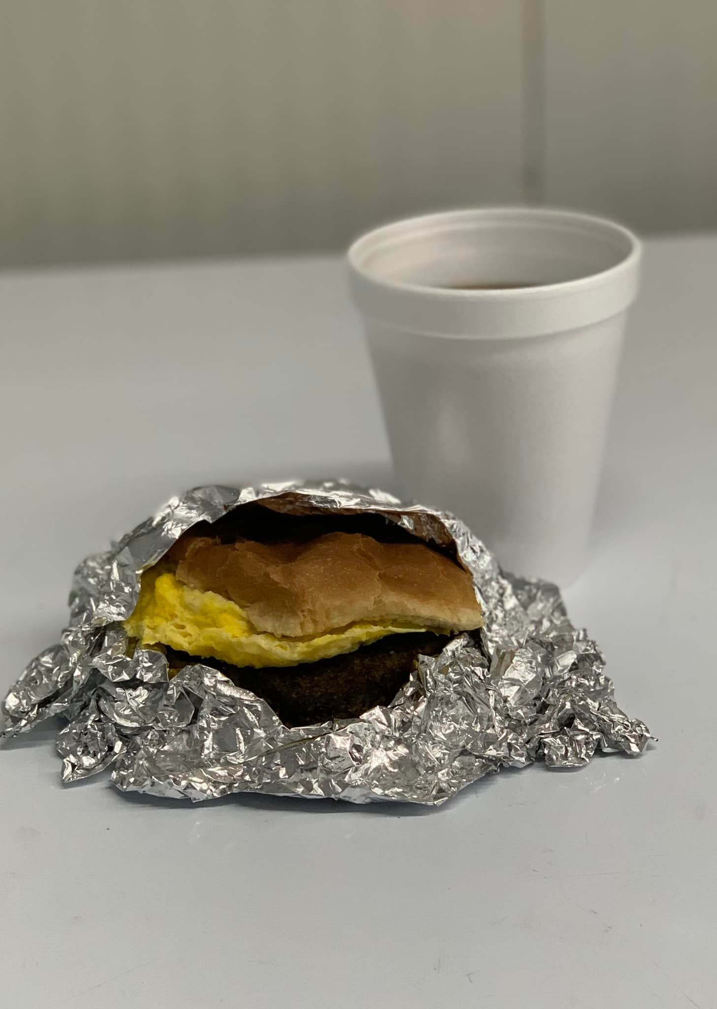 A house with a porch and a car parked in front of it.