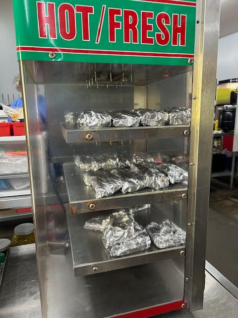 A vertical, stainless steel food warmer with 