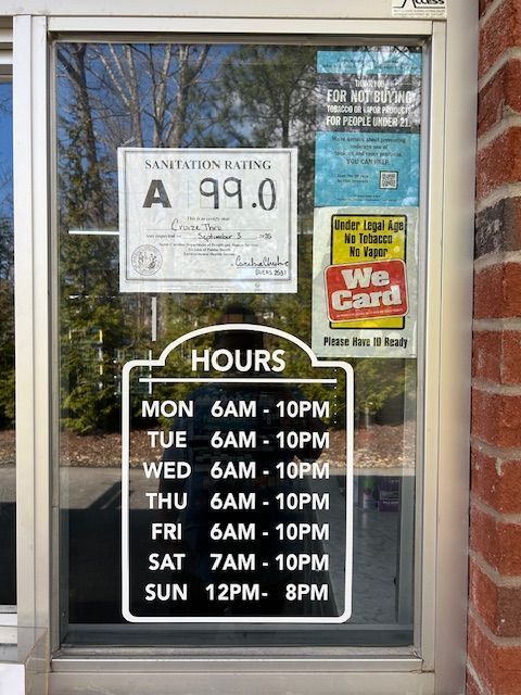 A cooler with ice, charcoal, and beer: Corona, Redd's, and Michelob Ultra, on wood chips, near rocks.