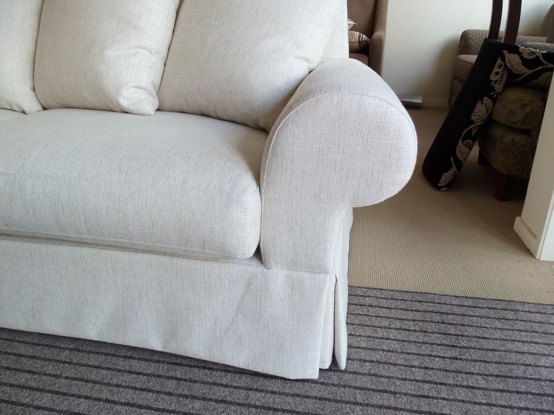 A white couch is sitting on a rug in a living room