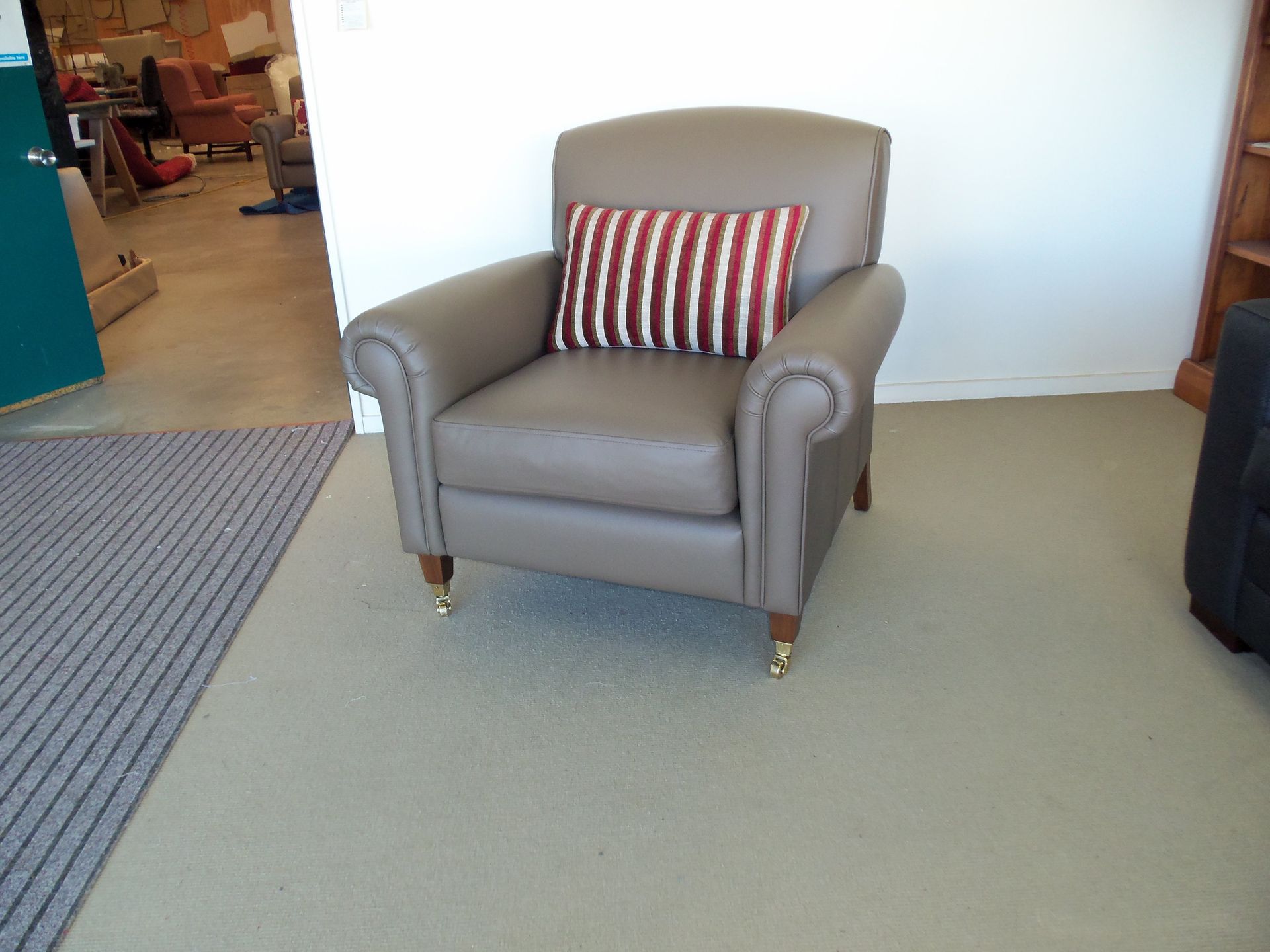 A chair with a red and white striped pillow on it
