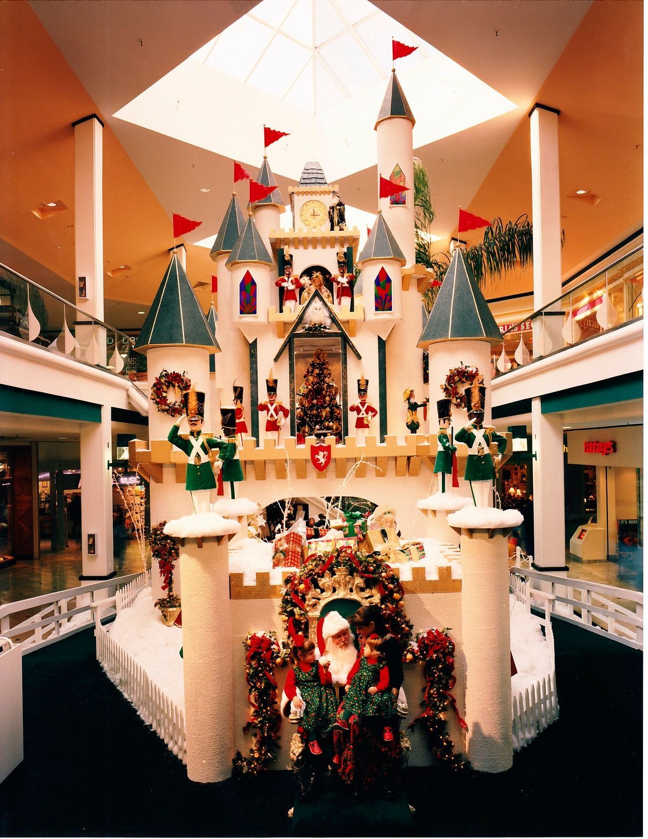 Christmas castle display in a mall with Santa, toy soldiers, and wreaths.