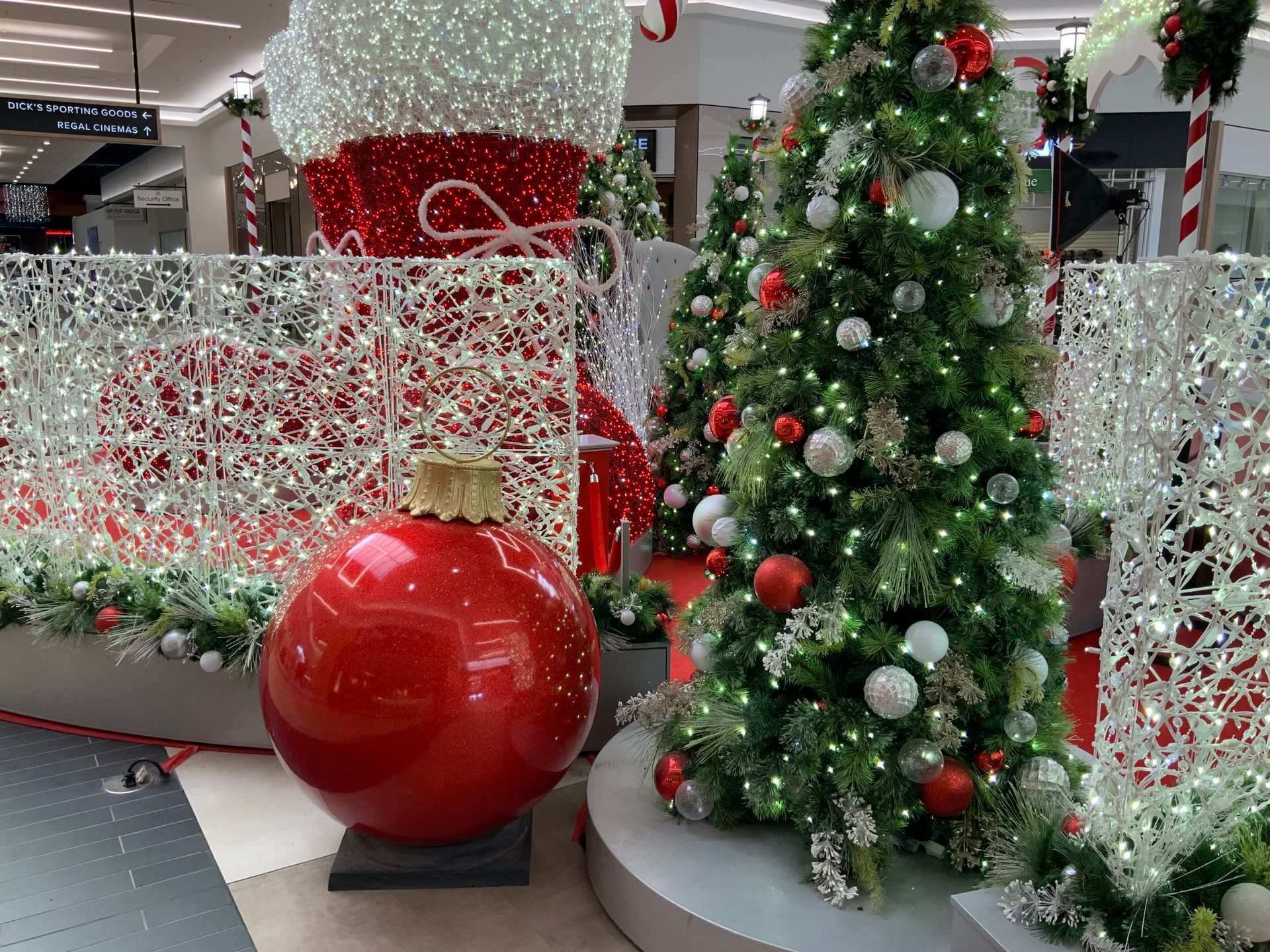 Mall Christmas decorations: large red ornament, tree, and giant stocking.