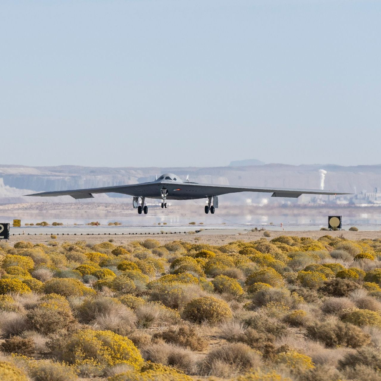 A fighter jet is taking off from a runway in the desert.