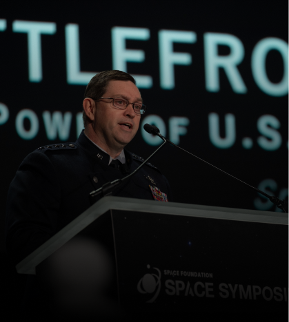 A man is giving a speech at a space symposi