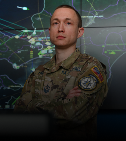 A man in a military uniform is standing in front of a map.