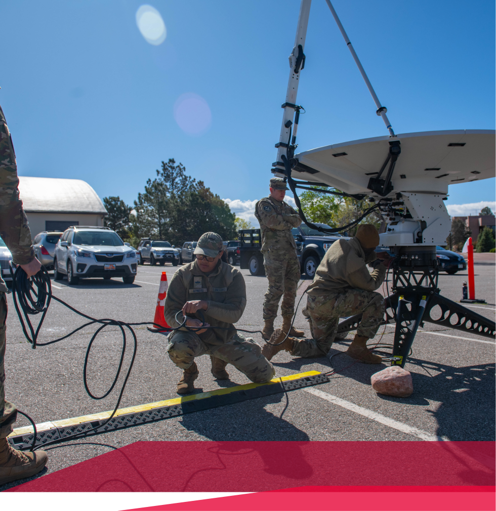 A group of soldiers are working on a satellite dish