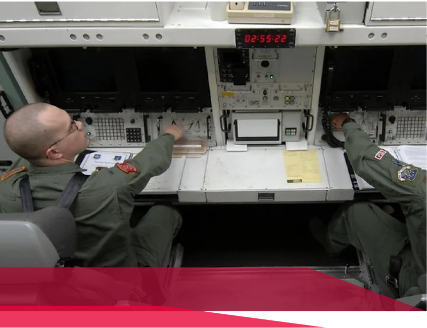 Two men are sitting at a desk with a digital display that says dfss-22