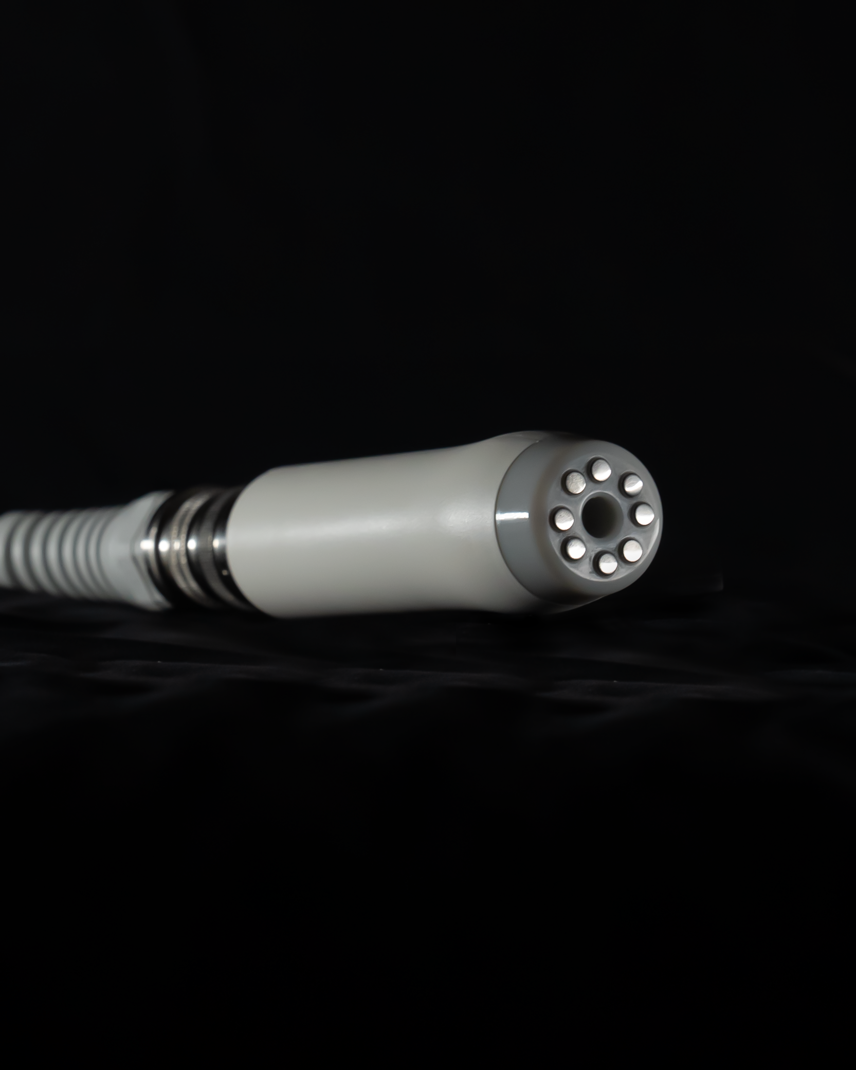 Close-up of a white medical device, likely a camera or light source, with multiple circular openings .