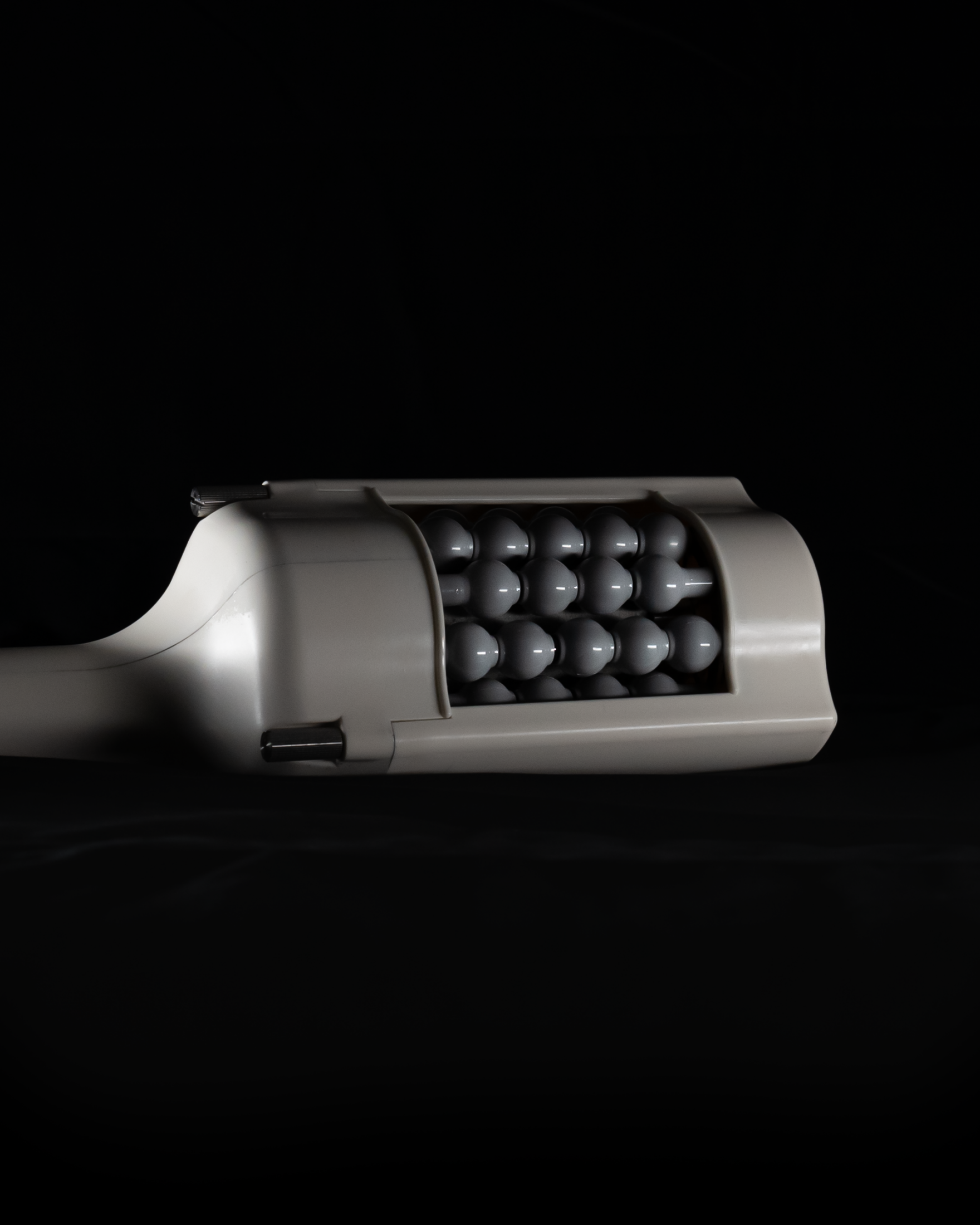 Cutaway view of a gray tube with a spherical interior, possibly for massage or muscle relief.