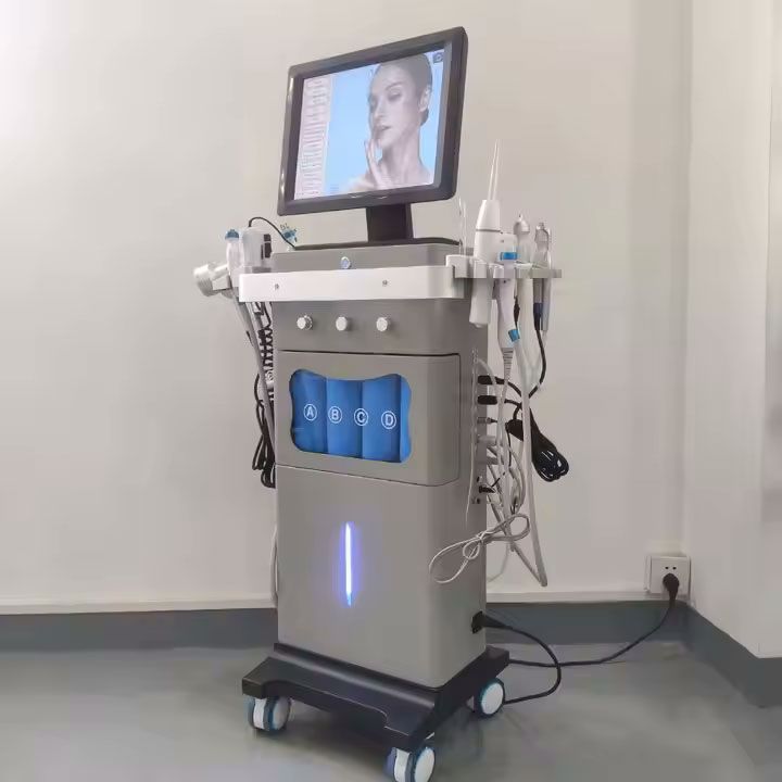 Skincare machine on wheels with attached wands, monitor, and liquid tanks. Displays a woman's face on the screen.