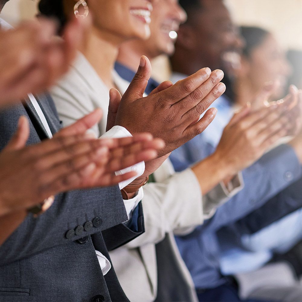 A group of people are clapping their hands together in a row