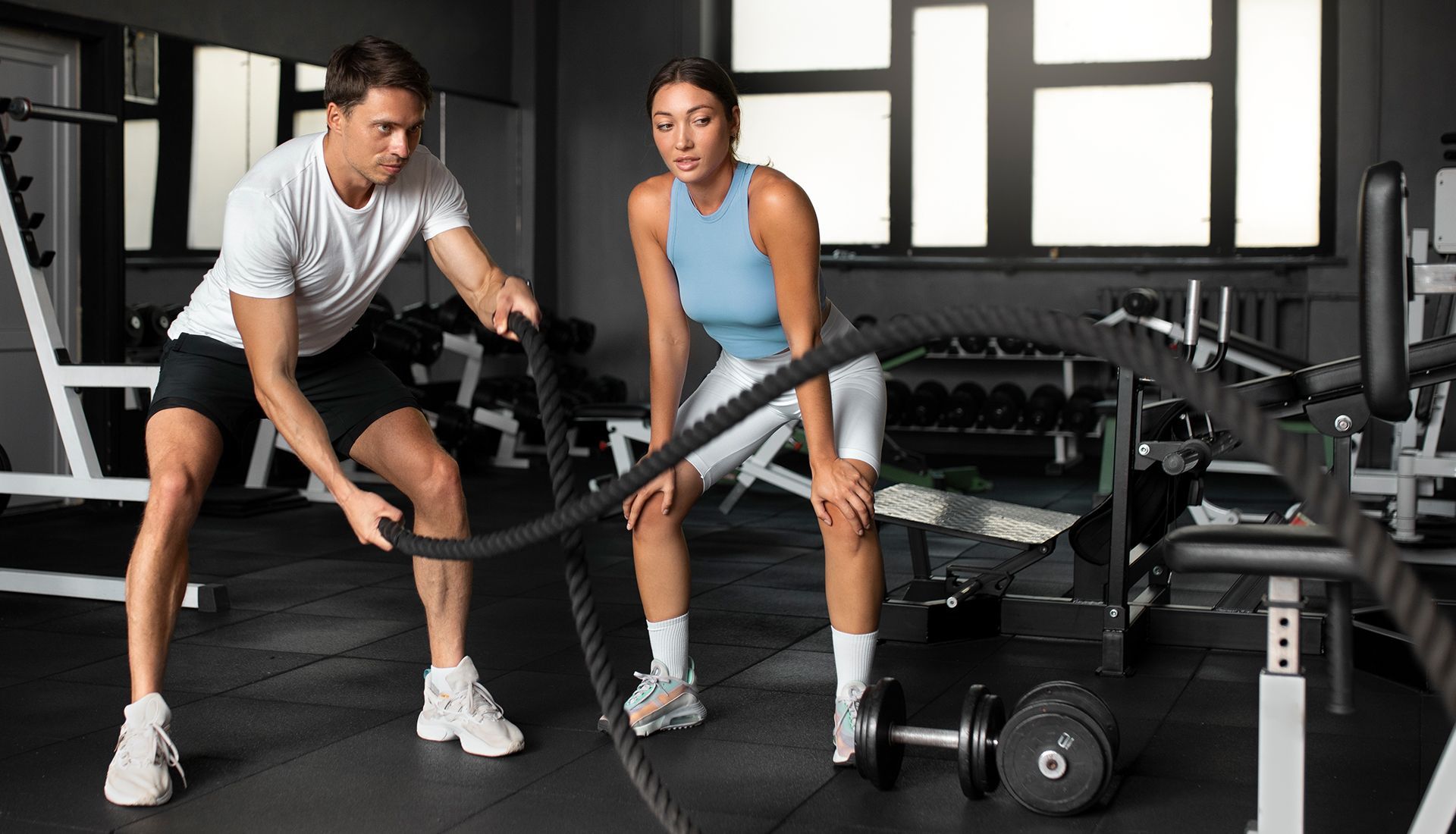 A man and a woman are doing exercises in a gym.