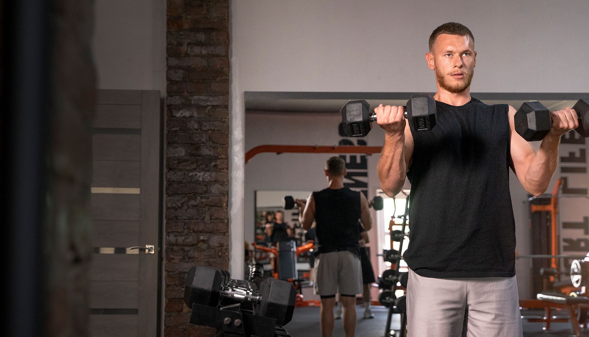 A man and a woman are doing exercises in a gym.