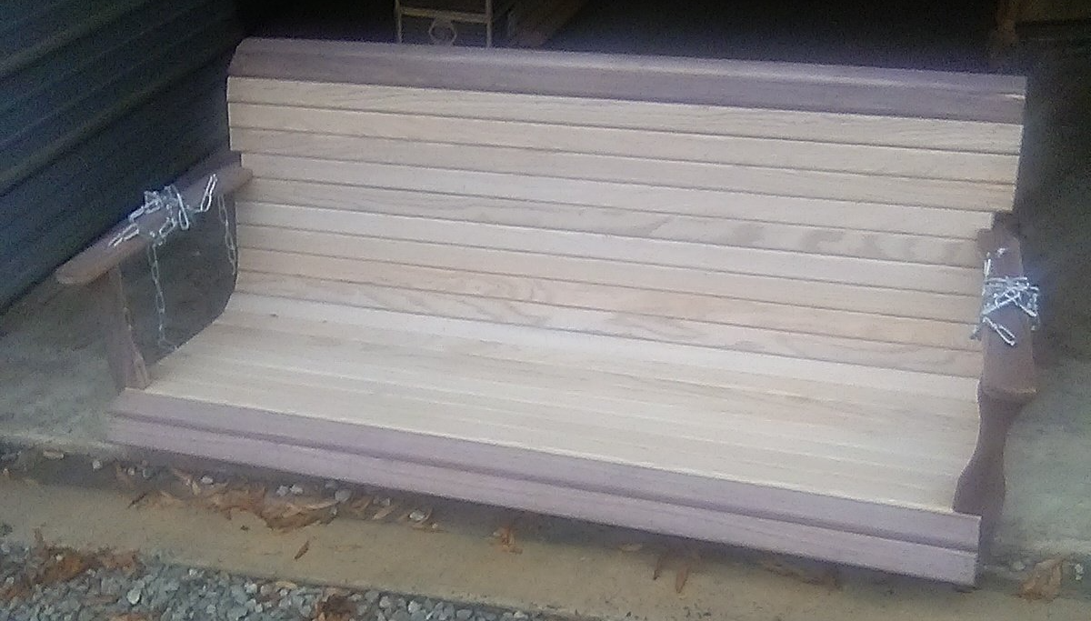 A wooden bench is sitting on top of a pile of wood.