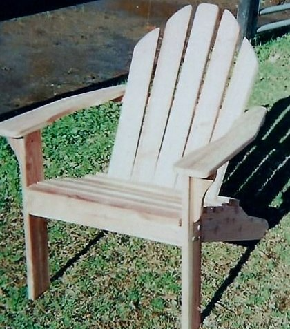 A wooden adirondack chair is sitting in the grass