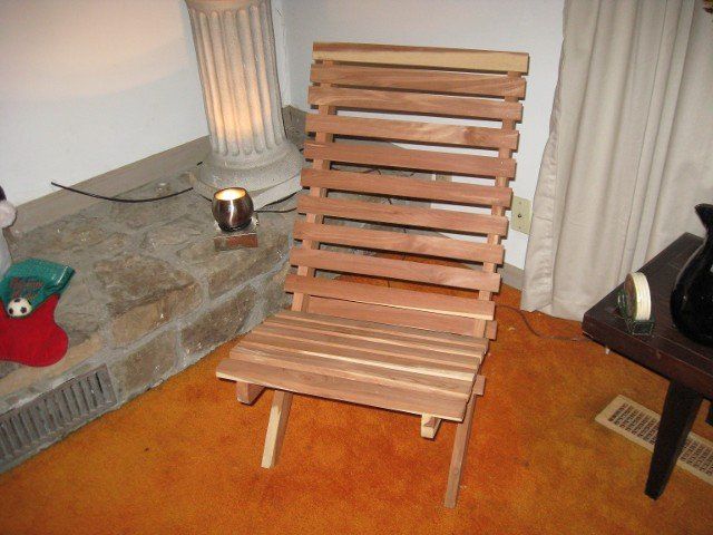 A wooden chair sits in a living room next to a fireplace