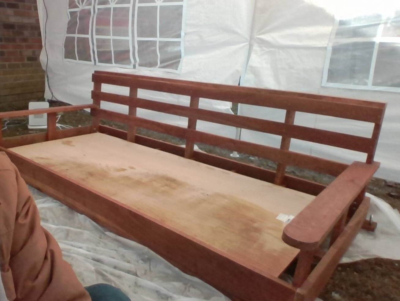 A wooden bench is sitting in front of a white tent
