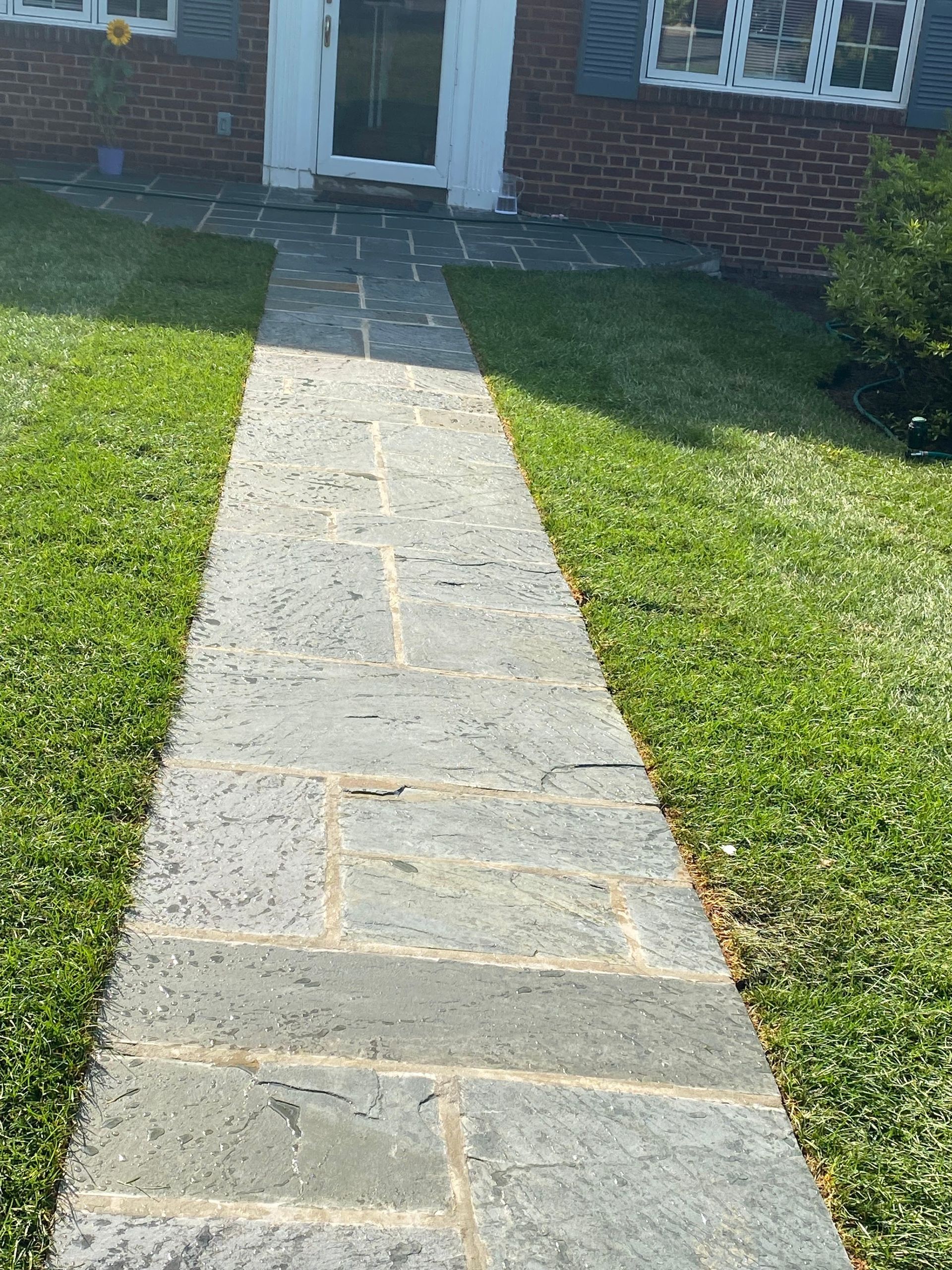 A stone walkway leading to a brick house