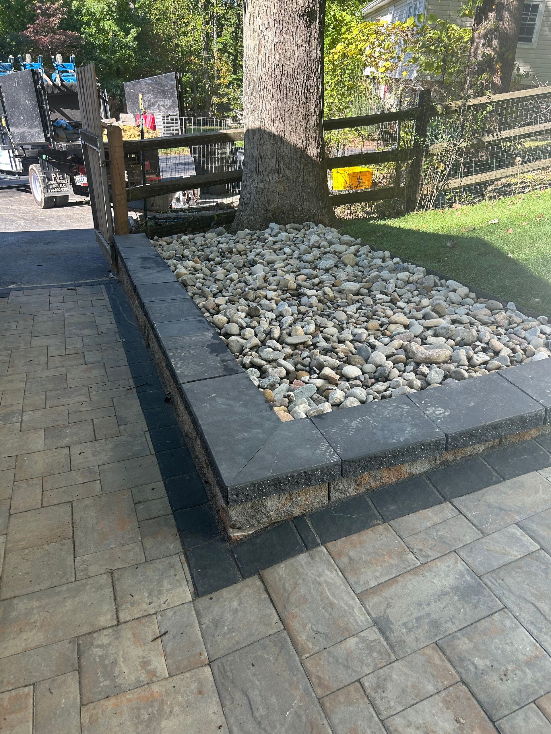 A bench is sitting on top of a pile of rocks on a patio.