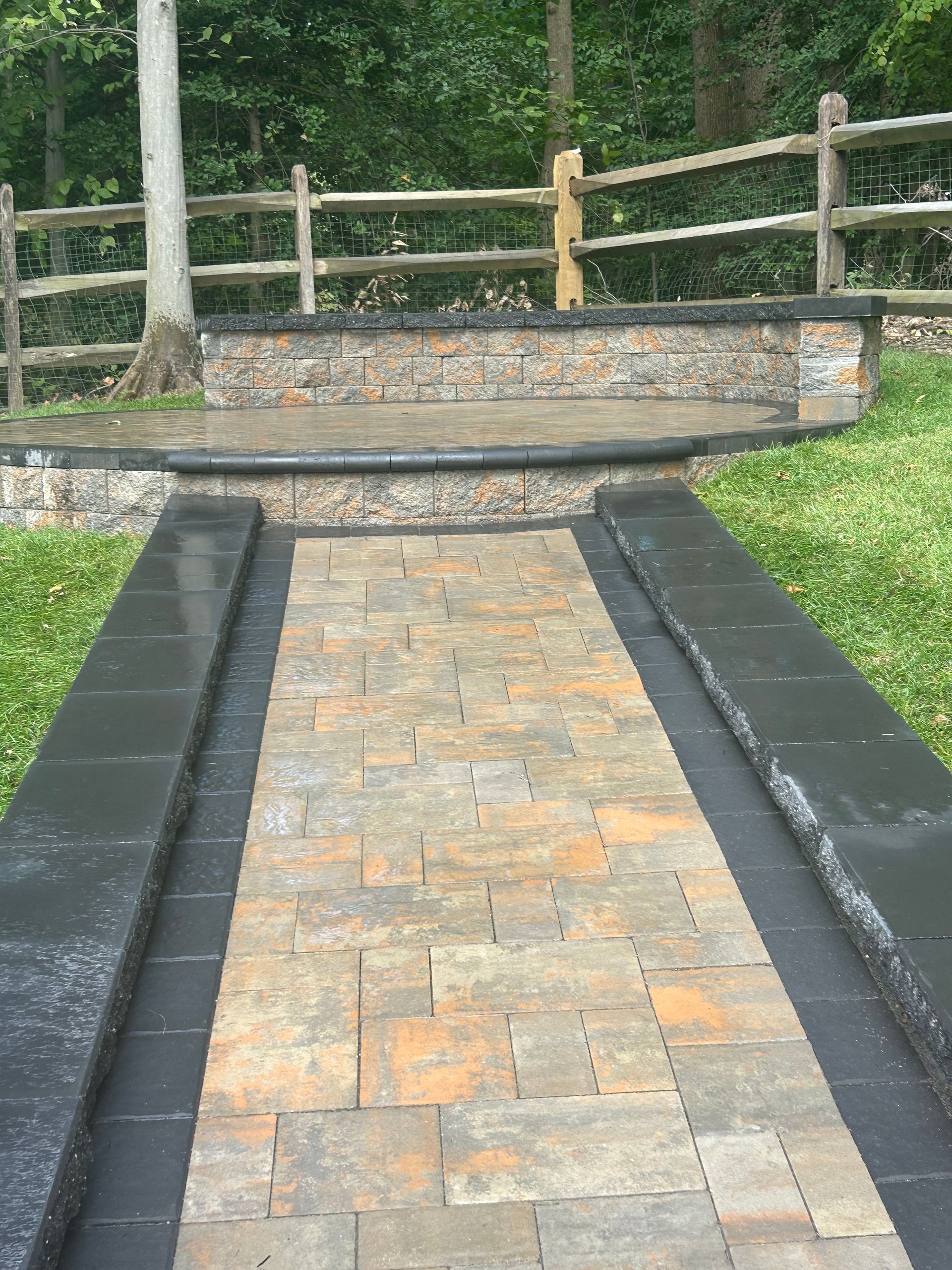 A brick walkway with a wooden fence in the background.