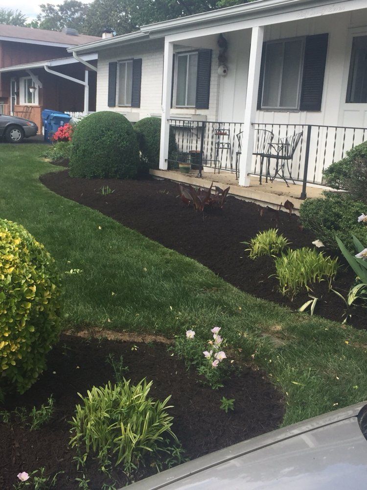 A house with a porch and a car parked in front of it