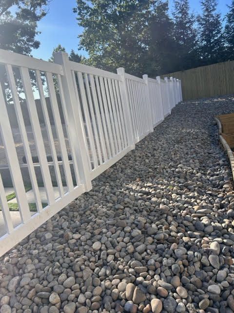 A white fence surrounds a gravel path.