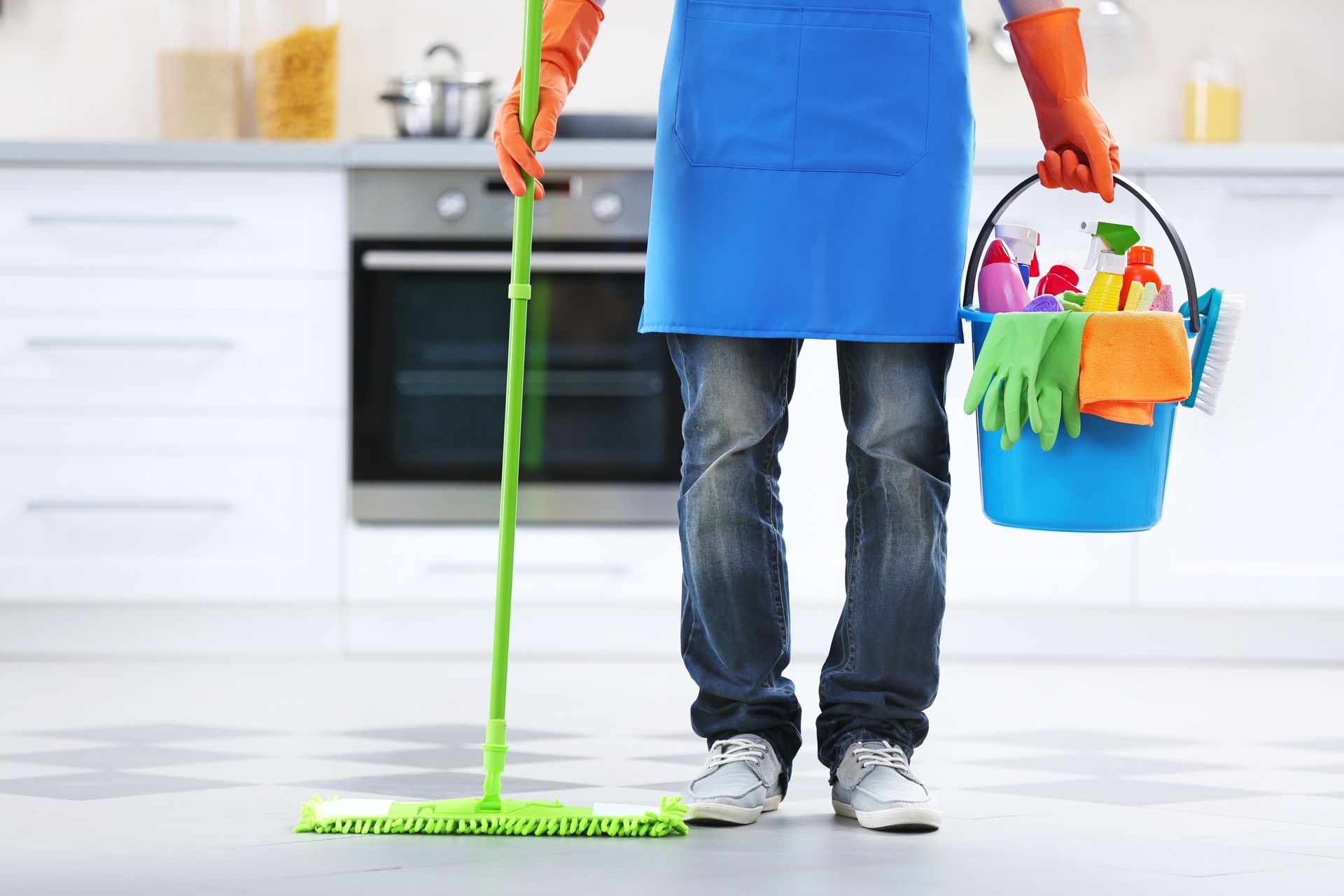 maid holding a mop and a bucket of cleaning products