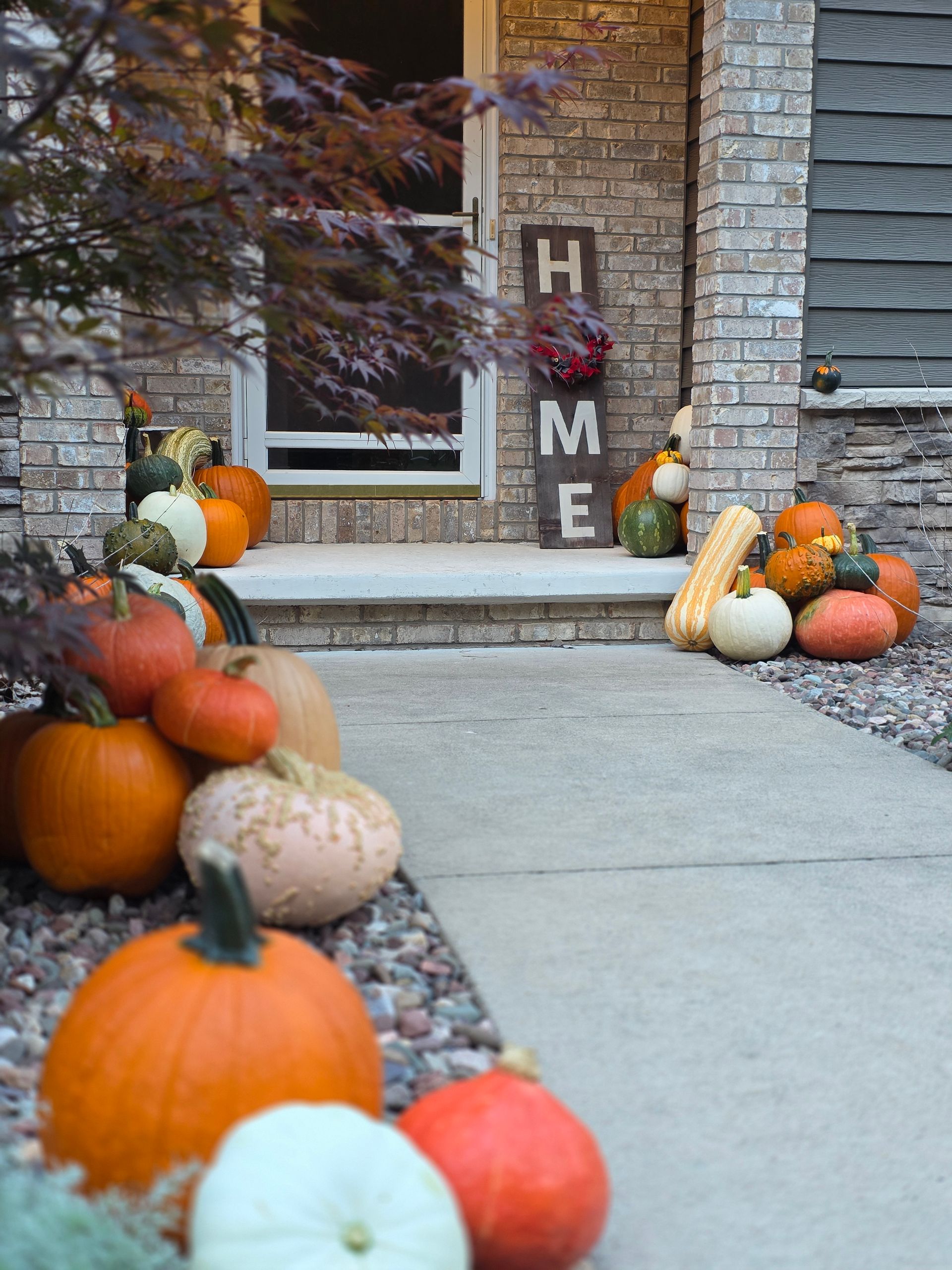 Fall porch decorated with pumpkins and a 