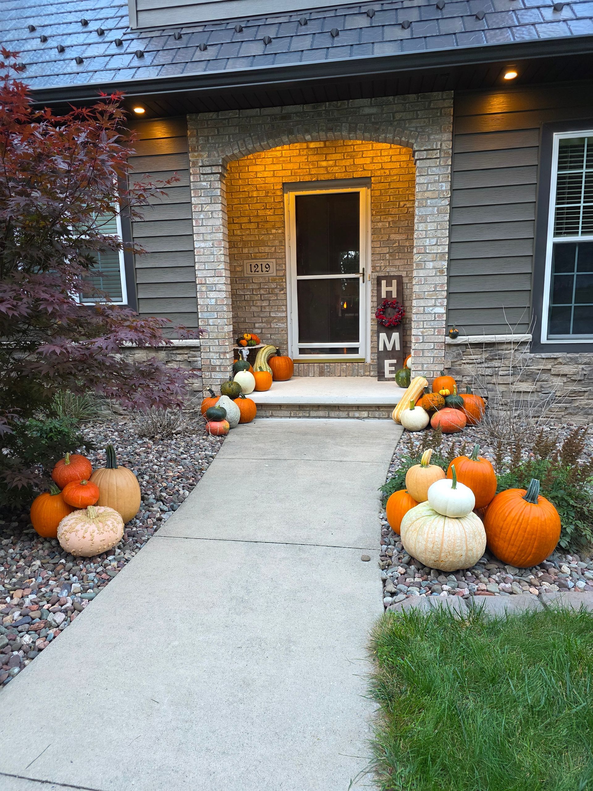 Fall-decorated front porch with pumpkins, gourds, and a 