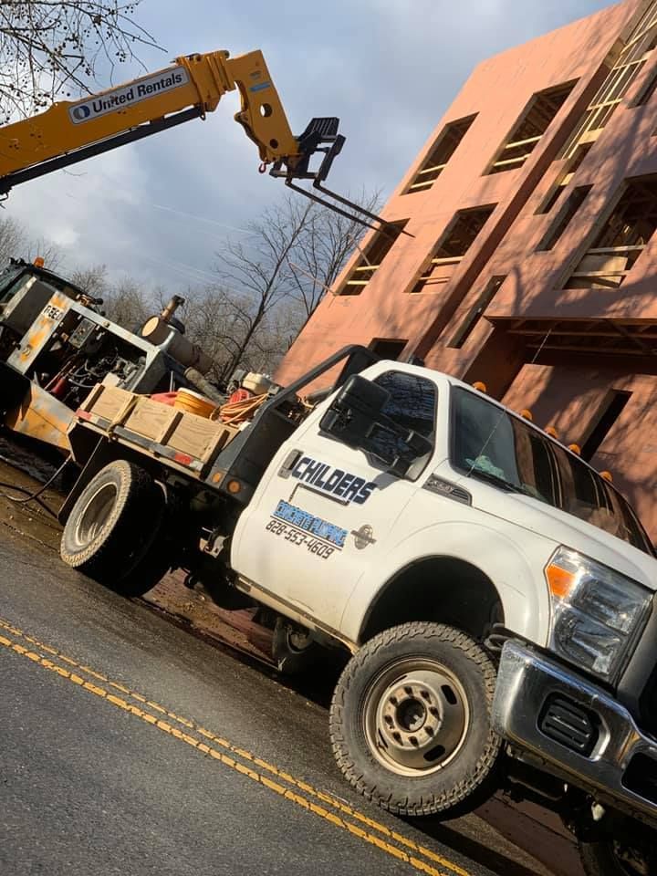 Construction truck and lift working on building.