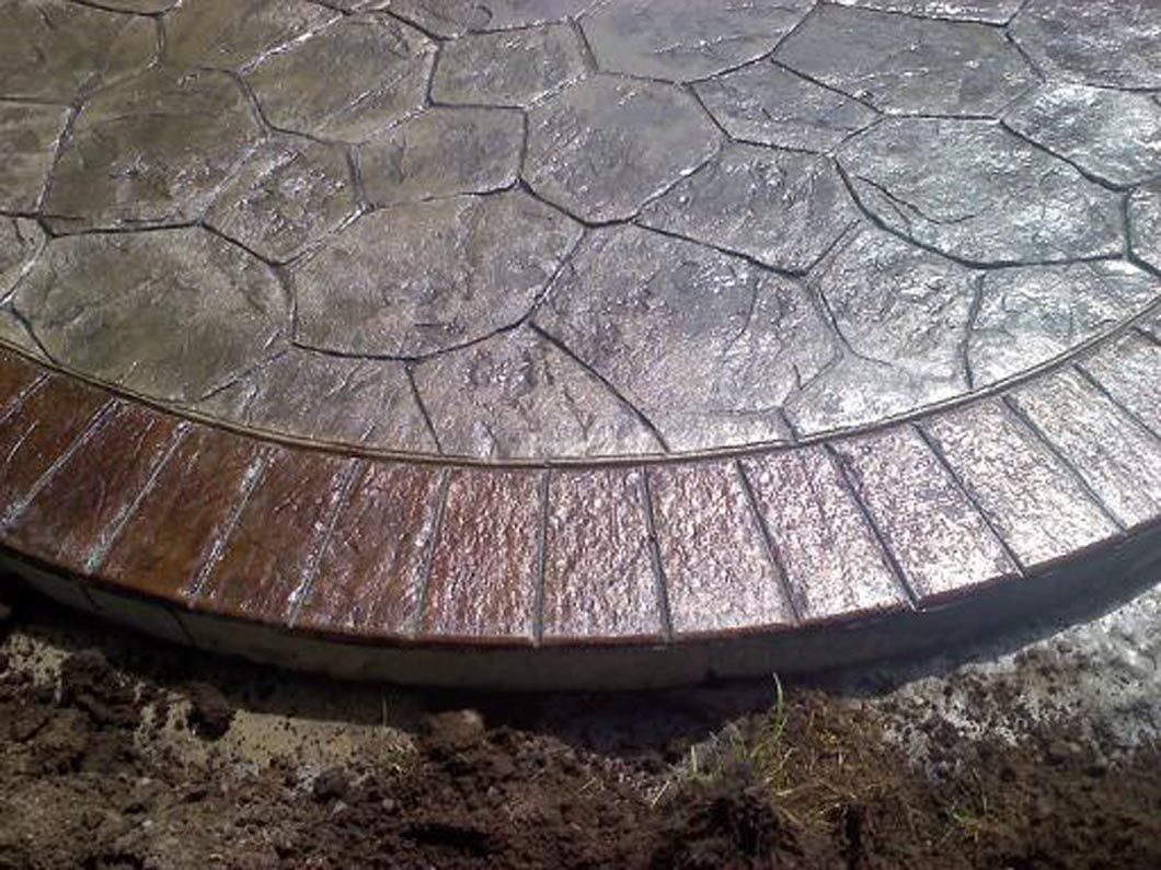 A close up of a concrete patio with a wooden border.