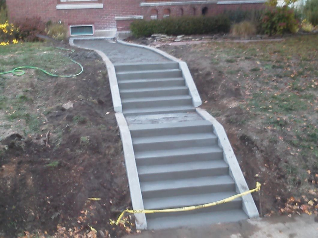A set of concrete stairs leading up to a house