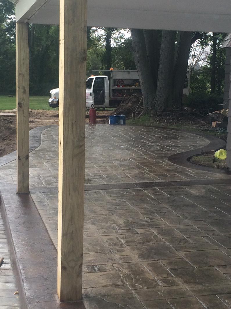 A wooden pillar is sitting on top of a concrete patio.