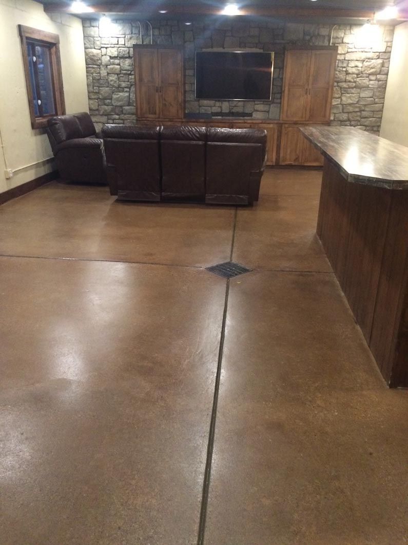 A living room with a couch , chair , television and a bar.