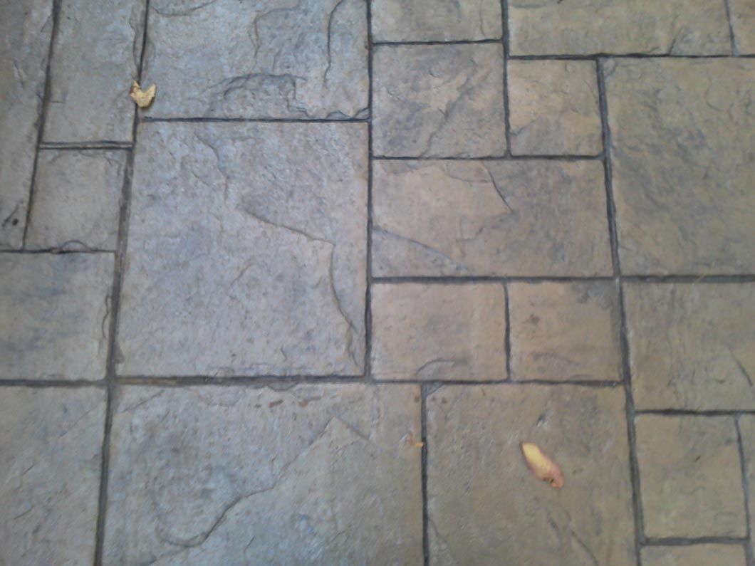 A close up of a brick floor with a leaf on it