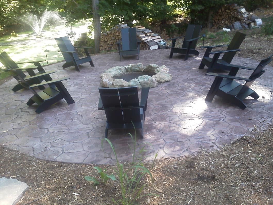 A group of chairs are sitting around a fire pit.