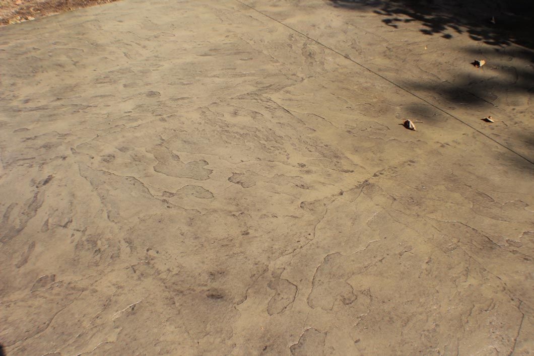A close up of a concrete surface with leaves on it.
