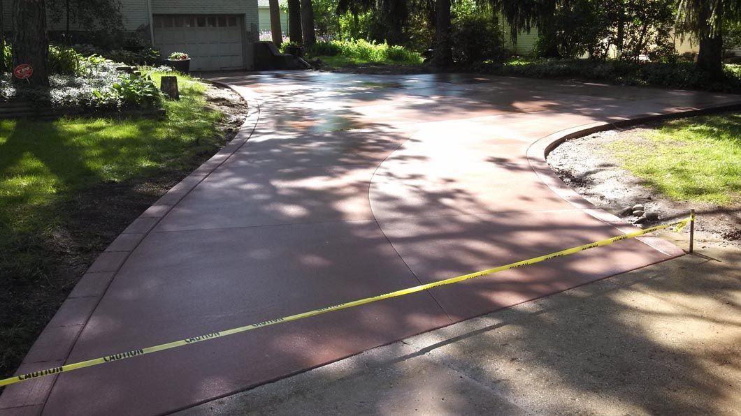 A concrete driveway with a yellow line on the side of it.