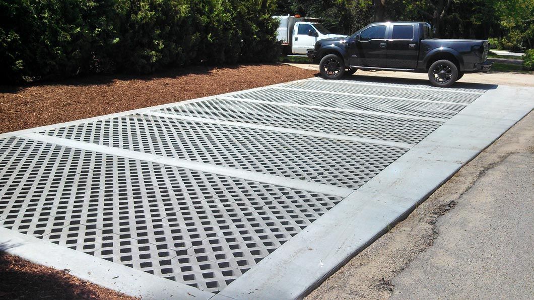 A black truck is parked in a concrete parking lot
