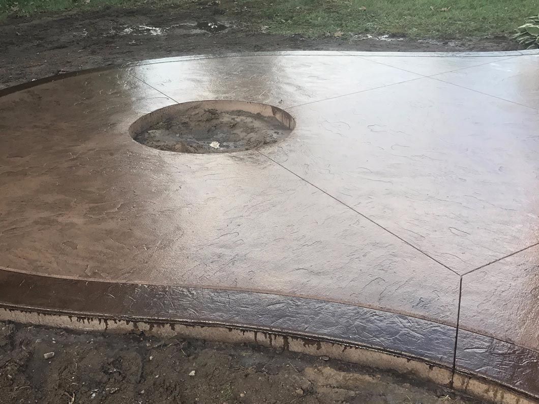A concrete patio with a hole in the middle of it.
