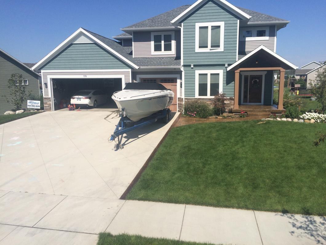 A boat is parked in the driveway of a house