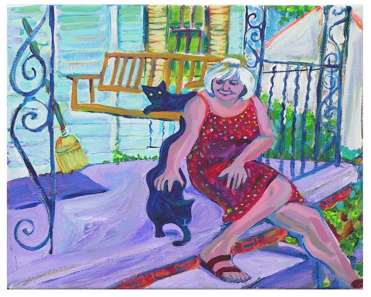 Woman in red dress on porch with two black cats.