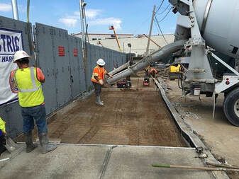 A concrete truck is pouring concrete on a construction site.