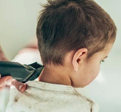 Shot of cute little boy getting haircut