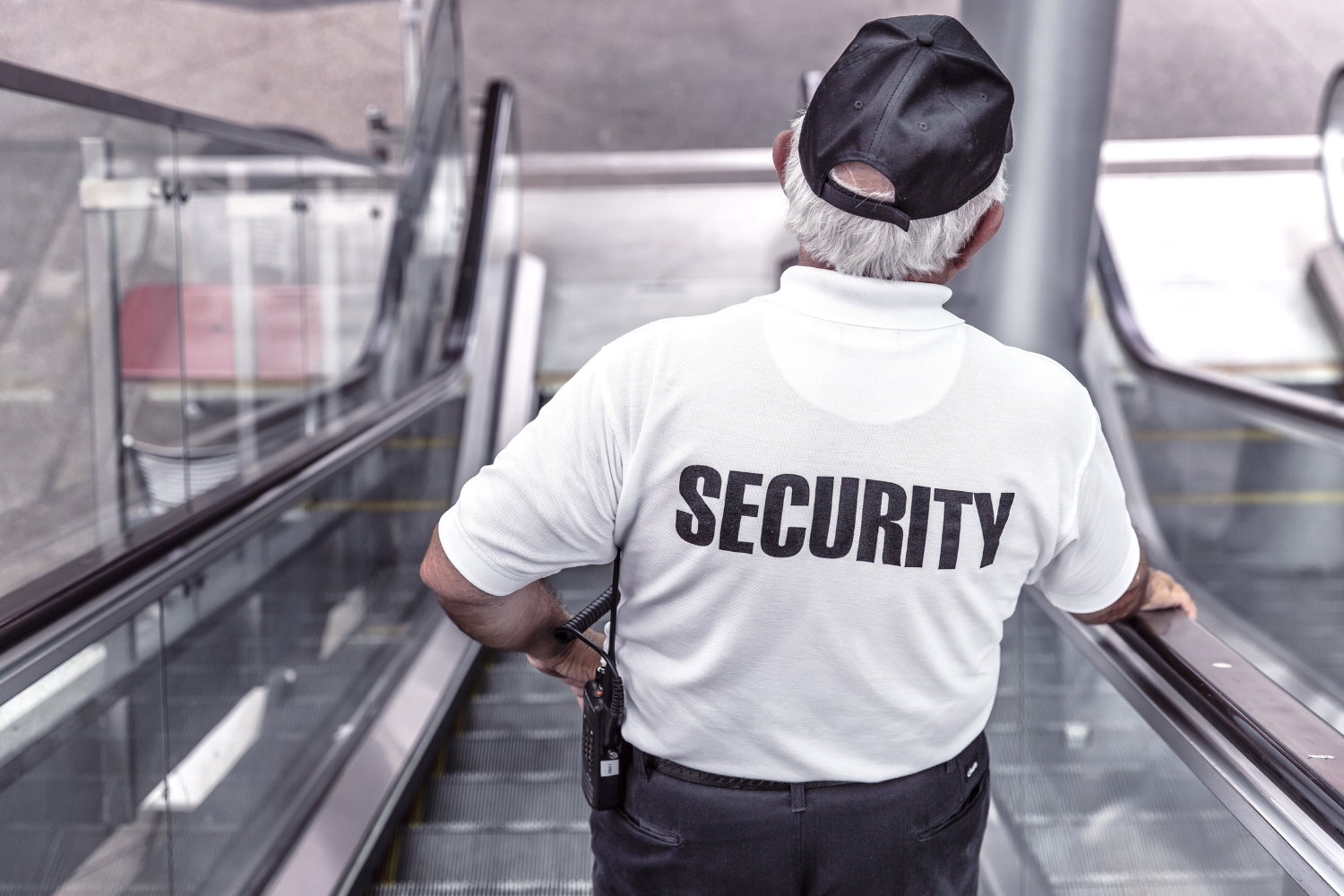 Security guard on escalator, white shirt with 