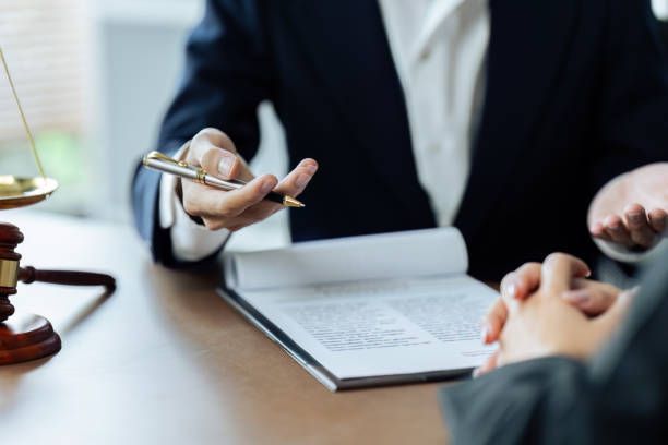 A lawyer is holding a pen while talking to a client.