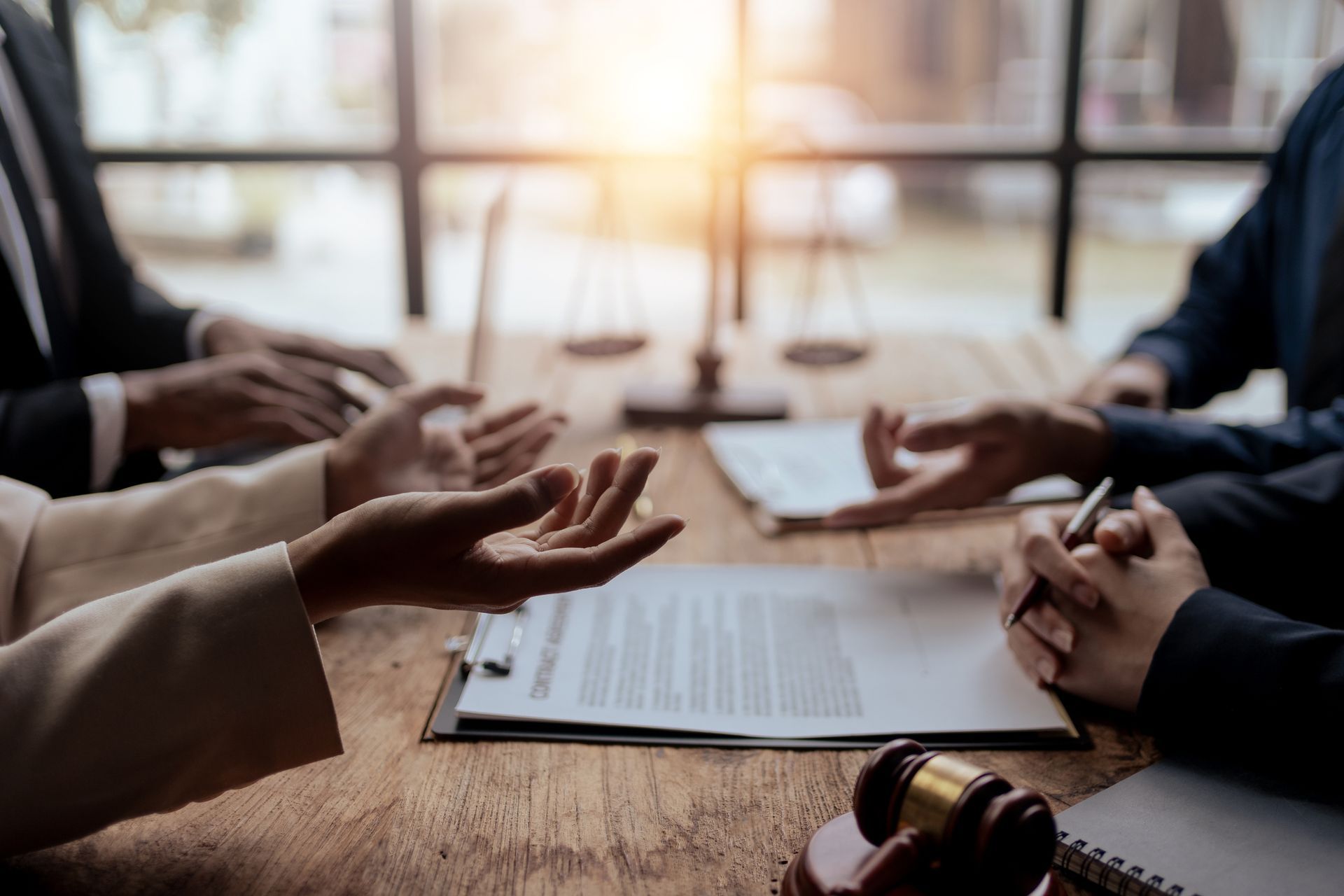 A group of lawyers are sitting at a table talking to each other.