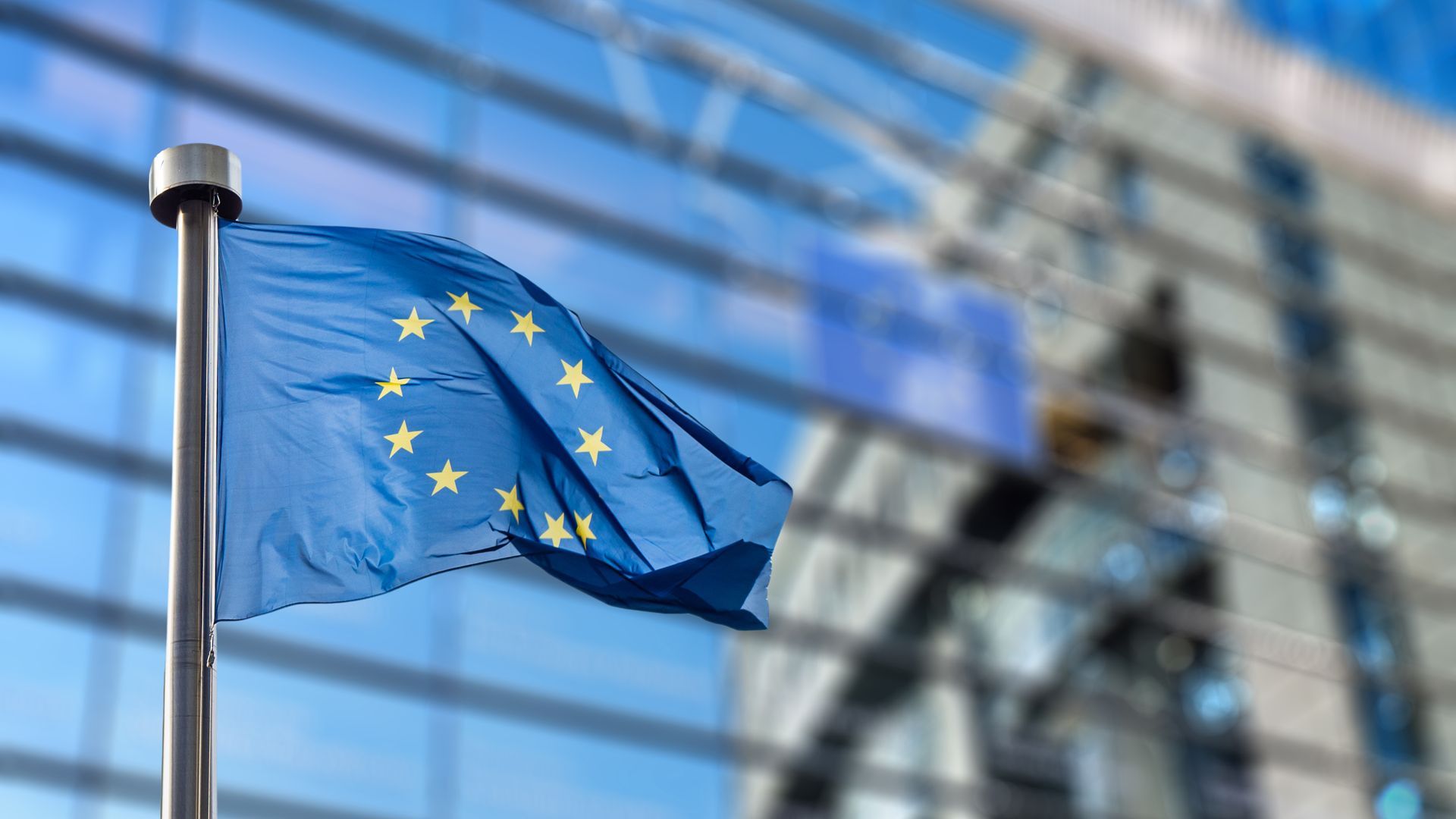 Flagge der EU vor einem Bürogebäude im Außenbereich